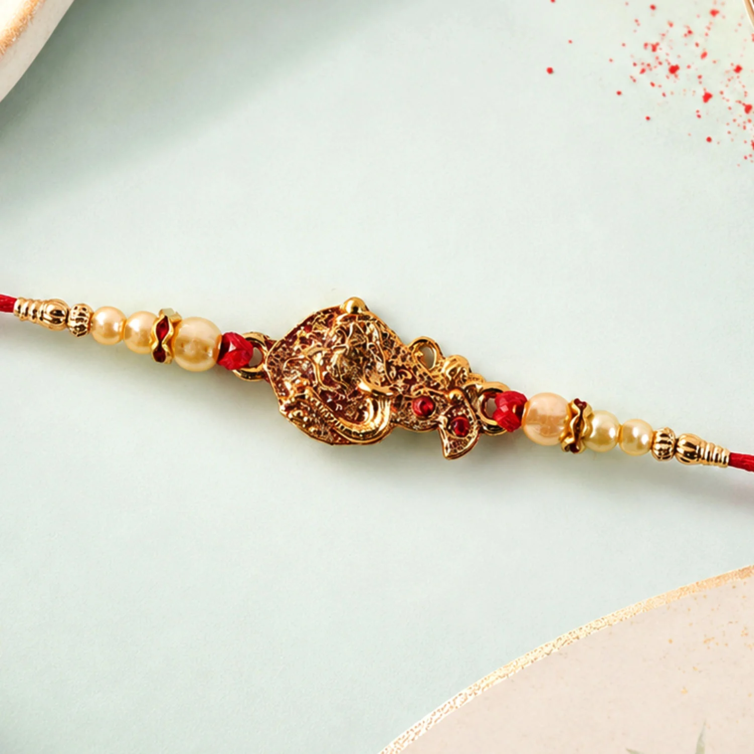 Golden Peacock Rakhi – Pearl Beads & Red Thread for Brother on Raksha Bandhan - Image 3